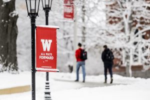 An All Ways Forward W Banner brightens a snowy winter morning as students walk along the sidewalk on Bascom Hill at the University of Wisconsin-Madison during a class change on Jan. 26, 2016. (Photo by Bryce Richter / UW-Madison)