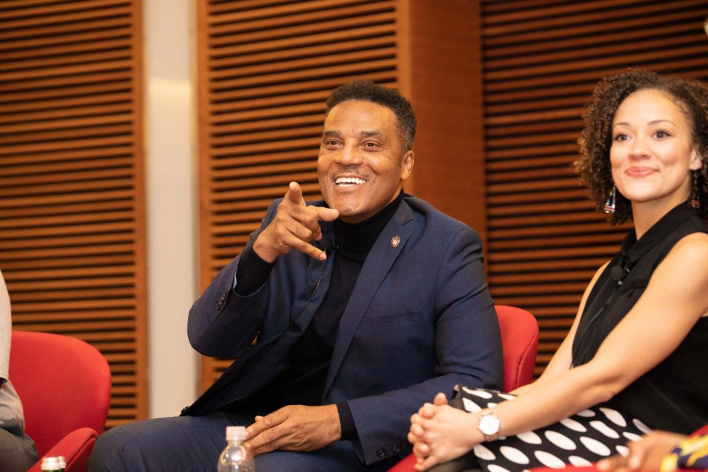Frank Gatson Jr. points at someone out of frame while Rebecca Arends smiles looking at the same person.
