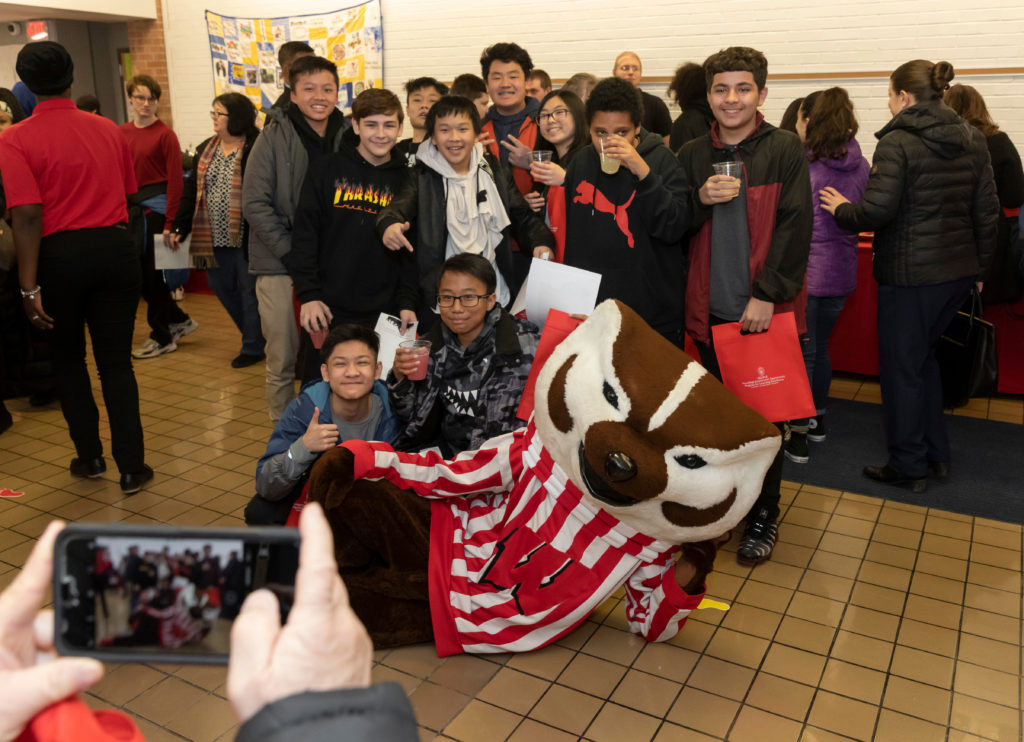 Students enjoy taking pictures with Bucky at the Grand opening of PEOPLE Program in Milwaukee Feb. 27, 2019. (Photo © Andy Manis)