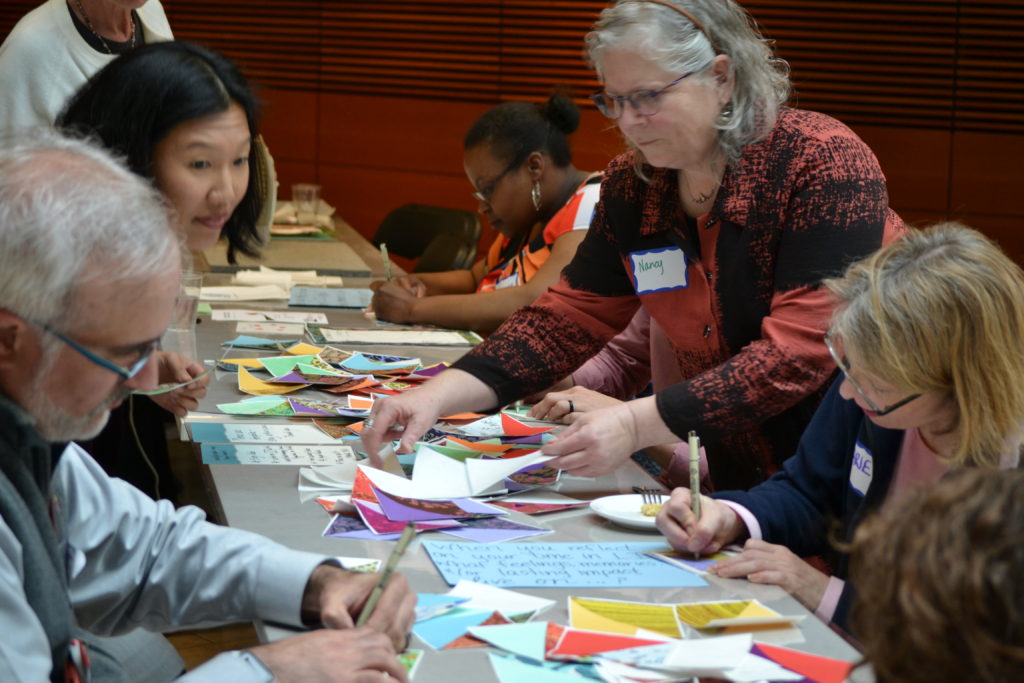 LI 20th Anniversary participants from Left Steve Shockler, Laura Klunder, Tanika Rumph, write congratulatory thoughts on cloth that will be assembled into a quilt by Nancy Blake (standing right). Far right, Marie Koko.