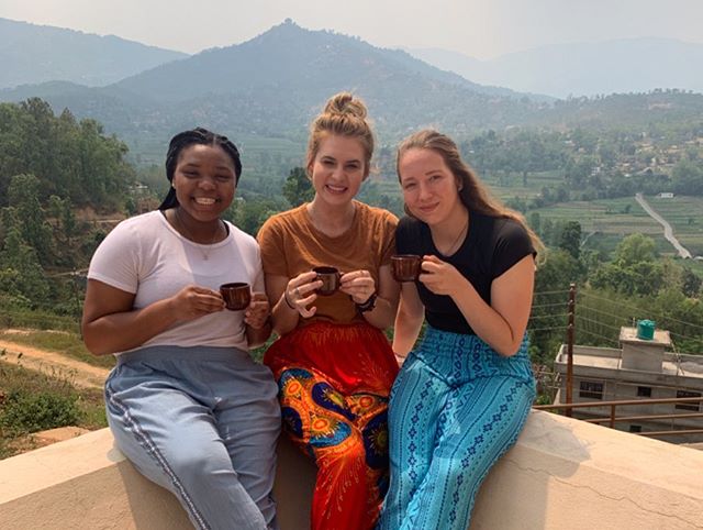 Kaitlyn Jackson, who journeyed to Nepal to study UW Global Health Community Health and Health Disparity, takes a taste of the local beverage with other student travelers. 