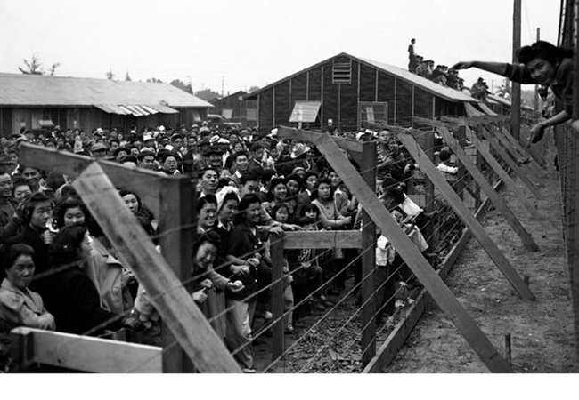 Japanese American citizens held in an American confinement camp following the bombing of Pearl Harbor, which brought the nation's west coast into World War II. Photo from the University of California -Berkley Library.