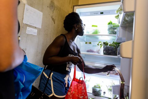 At center, Gbemisola Famule, a recent microbiology graduate of UW–Madison, helps herself to refrigerator-stored vegetables and produce during the grand opening event for the UW Campus Food Shed. PHOTO: JEFF MILLER