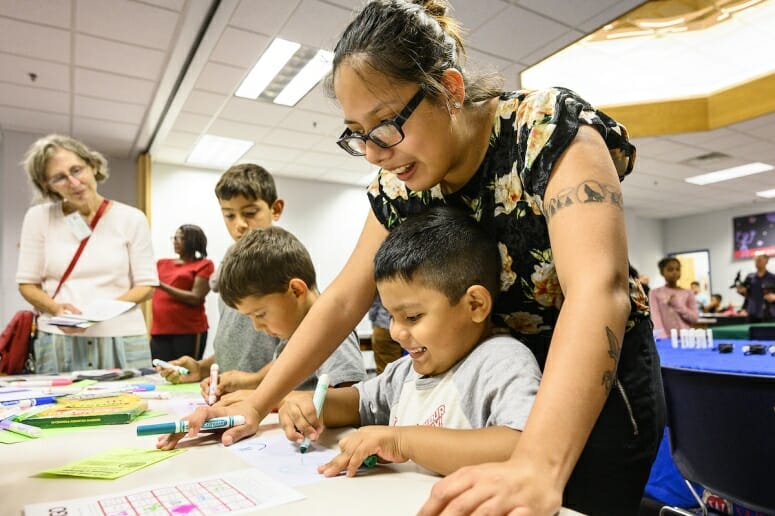 Ashad McLean (right) listens to Olympia Mathiaparanam, research specialist at the Wisconsin Center for Education Research, at a Lakeshore Nature Preserve education table. Photo by: Bryce Richter