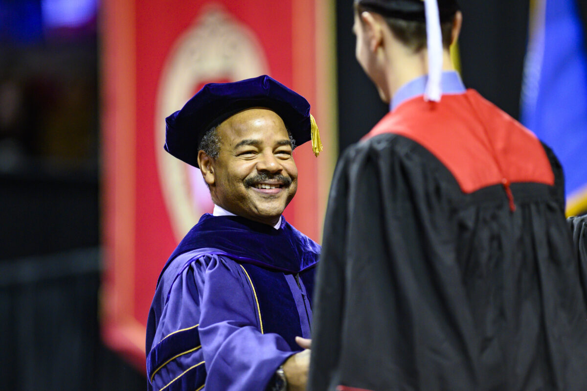 Eric Wilcots shakes a graduate’s hand during the winter commencement ceremony held in the Kohl Center on Dec. 15, 2019. PHOTO: BRYCE RICHTER