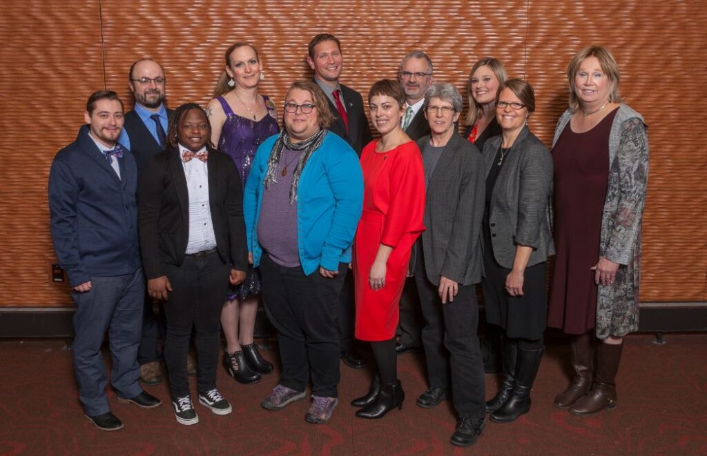 A group of people stand together posing for a group photograph.