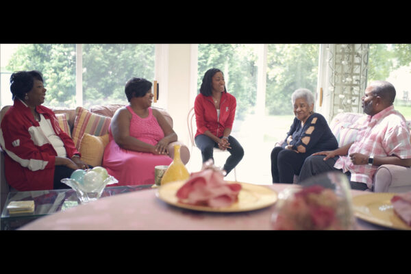 Screenshot of Alex Gee and his family sitting in a living room