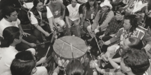 Black and white photograph of a Native American drum circle in the 1990s.