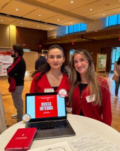 Two DDEEA Interns posing in front of a laptop at the DDEEA Reception following the Undergraduate Research Symposium